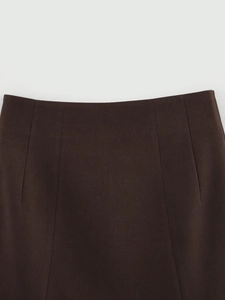 Detail of dark brown tailored suit fabric showing fine twill texture and waistband finish