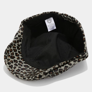 Detail view of leopard print PU leather beret showing inner lining and washing labels
