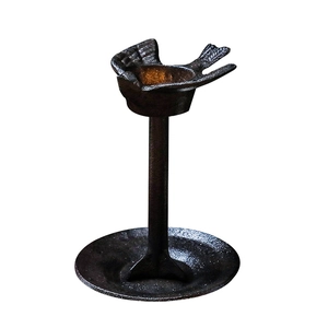 Porte-bougie oiseau en fonte de style japonais vintage sur un fond blanc épuré