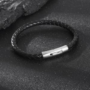 Macro detail of men's braided leather bracelet with polished stainless steel clasp
