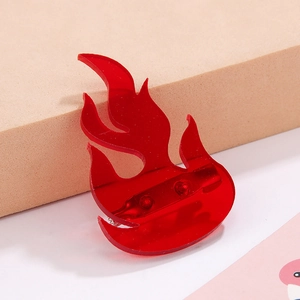 Macro shot of red translucent acrylic flame brooch with metal pin backing detail