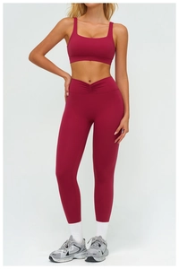 Close-up of deep burgundy high-waisted yoga leggings featuring a unique V-shaped cross waist design