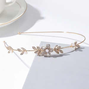 Détail du serre-tête fleuri doré avec des strass et des perles d'imitation