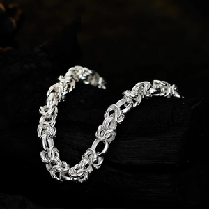 Elegant silver S925 sterling silver woven knot bracelet on a dark background