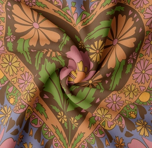 Close-up of vintage floral tapestry fabric with soft folds and detailed woven texture