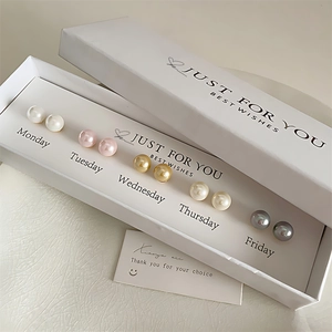 Close-up of 5 pairs of colorful pearl earrings in a Monday-Friday gift box set