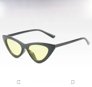 Close-up of cat-eye sunglasses with a black frame and light yellow lenses from a 45-degree angle