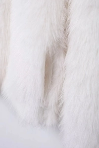 Gros plan de la texture douce et duveteuse d'une veste blanche en fausse fourrure