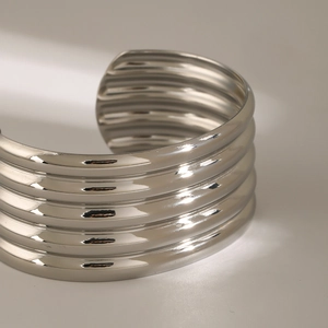 Detail of multi-layered silver stainless steel open bangle with polished finish