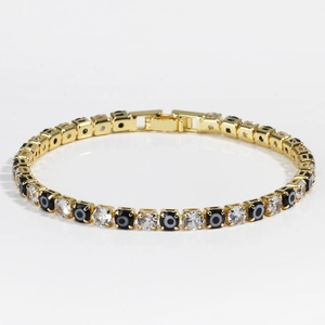 Detail of gold tennis bracelet with cubic zirconia and black evil eye charms clasp