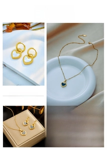 Detail of heart jewelry set with gold hoop earrings and pendant necklace on silk