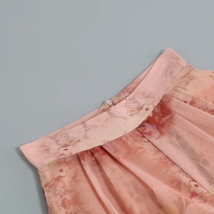 Detail of pink floral chiffon fabric featuring waist pleats and an invisible zipper closure