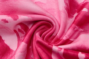 Macro view of pink and red tie-dye abstract print on high-quality knit dress fabric