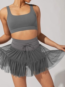 Detailed view of grey high-waisted pleated skirt with mesh layer and functional drawstring