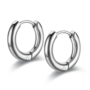 Close-up of polished silver titanium steel huggie earrings with high-gloss finish