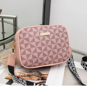 Pink geometric crossbody bag with textured triangular pattern and wide woven shoulder strap