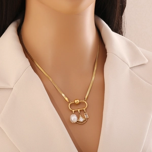 Gold stainless steel necklace featuring shell heart charms and pearls worn by a model