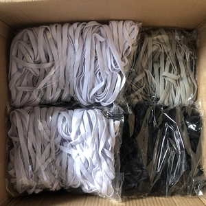 Bulk packaging of elastic sports headbands in white black and gray inside a shipping box