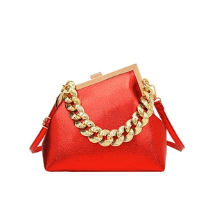Metallic red pearlescent handbag with gold chain handle and leather strap on white background