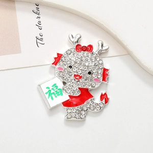 Detail of cartoon dragon brooch with white rhinestones and red enamel decoration