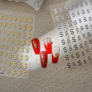 Detail of metallic gold and silver dollar sign nail stickers on red manicure samples