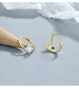 Detail view of 925 sterling silver hoop earrings with round zircon on wood stand