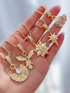 Detail view of five gold star and heart pendants inlaid with clear zircon crystals