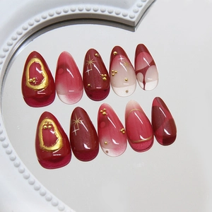 Deep red almond press-on nails with cat-eye effect and golden metallic accents
