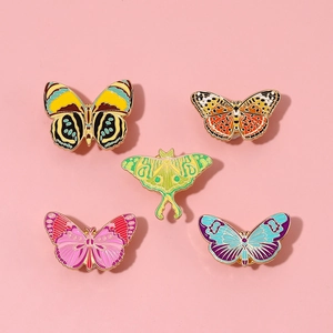 Detailed close-up of five colorful enamel butterfly and moth alloy brooch pins