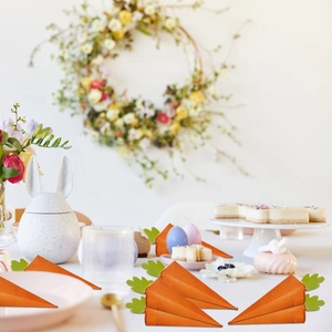 Carrot-shaped Easter candy boxes on a decorated festive table with bunny ornaments