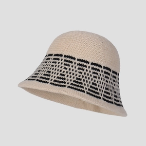 Detail of knit bucket hat featuring beige fabric and black geometric diamond pattern