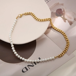 Close-up of pearl and gold-plated chain link necklace with lobster clasp on a white plate
