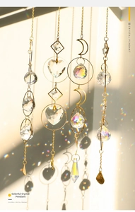 Detailed view of four golden crystal suncatchers casting rainbow light on a plain wall