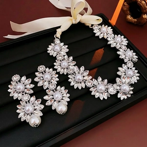 Sparkling diamond flower and pearl necklace with matching earrings on a display tray