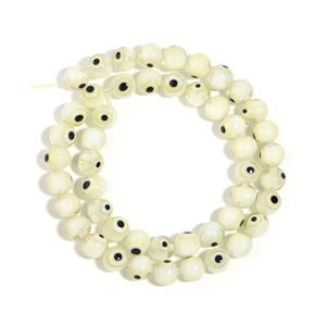 Creamy white millefiori evil eye glass beads in a circular arrangement for DIY jewelry
