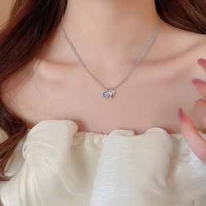 Detail of blue crystal and silver heart pendants on beaded chain necklace for women
