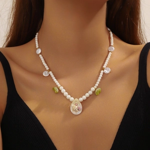 Detail view of pearl necklace with seashell pendant and colorful bohemian beads