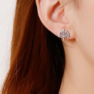 Close-up of minimalist silver tree of life stud earring worn on a female ear lobe