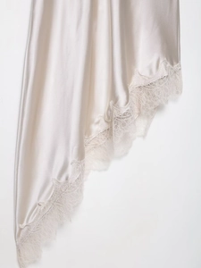 Close-up of champagne silk dress hem featuring delicate lace trim and satin texture