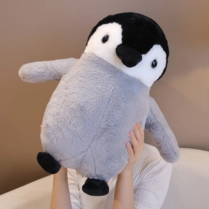 Detail of a large soft penguin plush toy being held to show texture and size