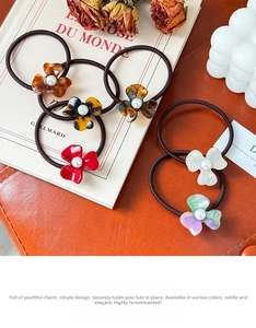 Detailed shot of acetate flower hair ties with pearls on vintage background props