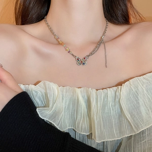 Close-up of a butterfly pendant necklace with colorful rhinestones on a model's neck