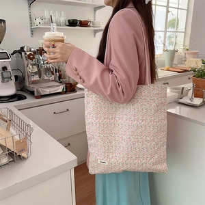 Sac fourre-tout en toile à fleurs porté par un mannequin dans un café douillet