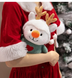 Close-up of plush reindeer doll wearing a dark green knitted sweater with red heart embroidery