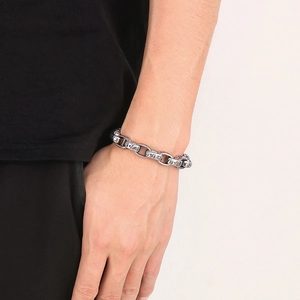 Macro shot of silver punk chain bracelet featuring Egyptian pharaoh patterns on metal links