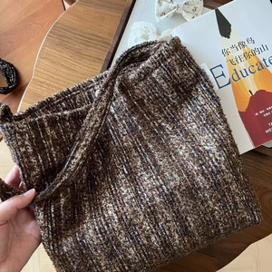Macro detail of the retro brown tweed fabric texture on a vintage style shoulder bag