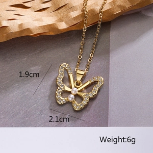 Macro detail of gold butterfly pendant with pearls and rhinestones showing 2.1cm width