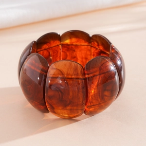 Detailed view of an amber marbled resin elastic bracelet with oval segments