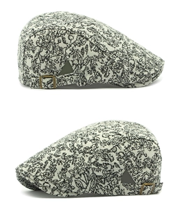 Detail of vintage floral pattern jacquard fabric and metal side buckle on newsboy cap