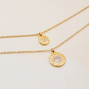 Double-layered gold stainless steel necklace with sparkling crystal starburst pendants